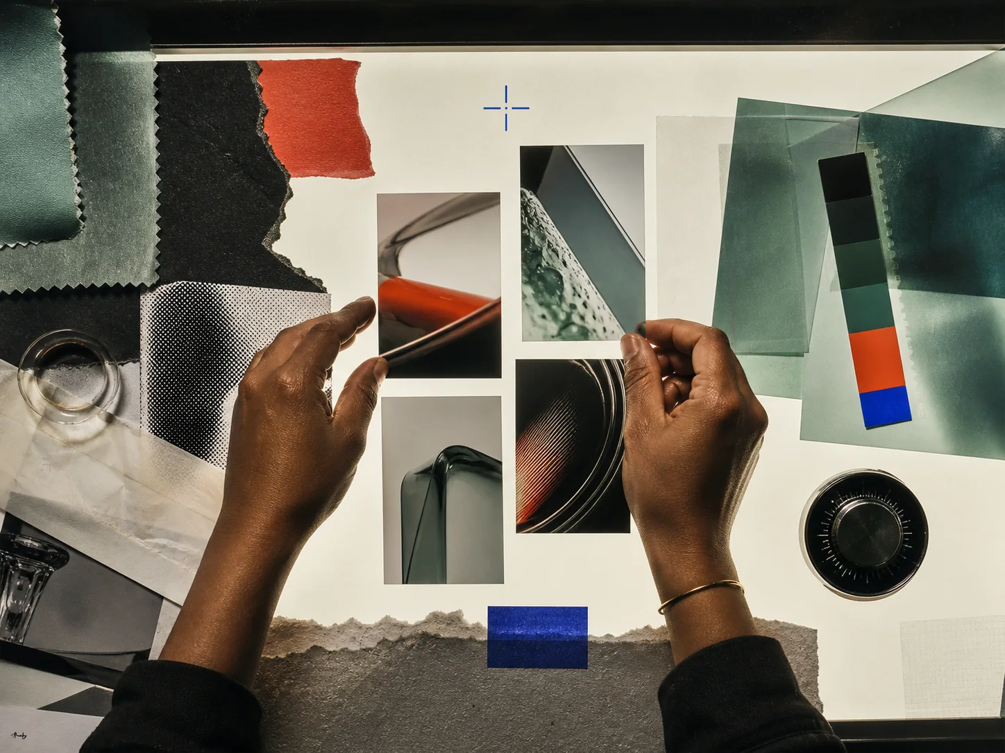 Hands arranging campaign frames and visual materials on a studio light table
